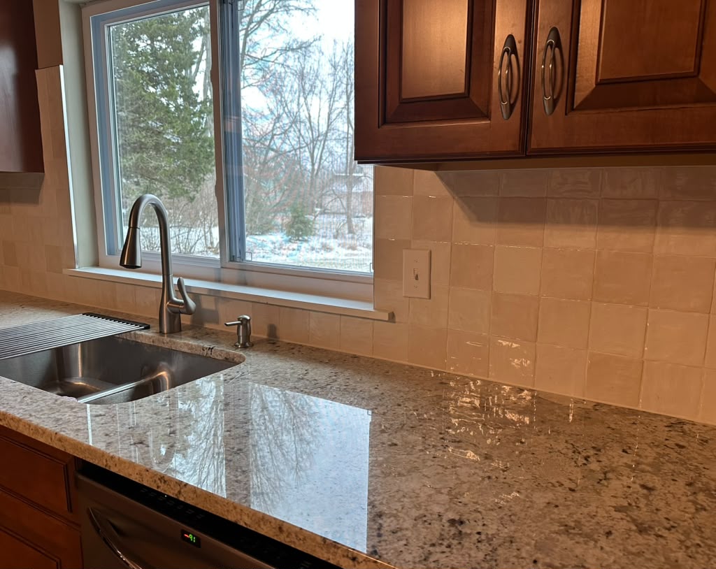 Kitchen granite counter and glossy tile backsplash