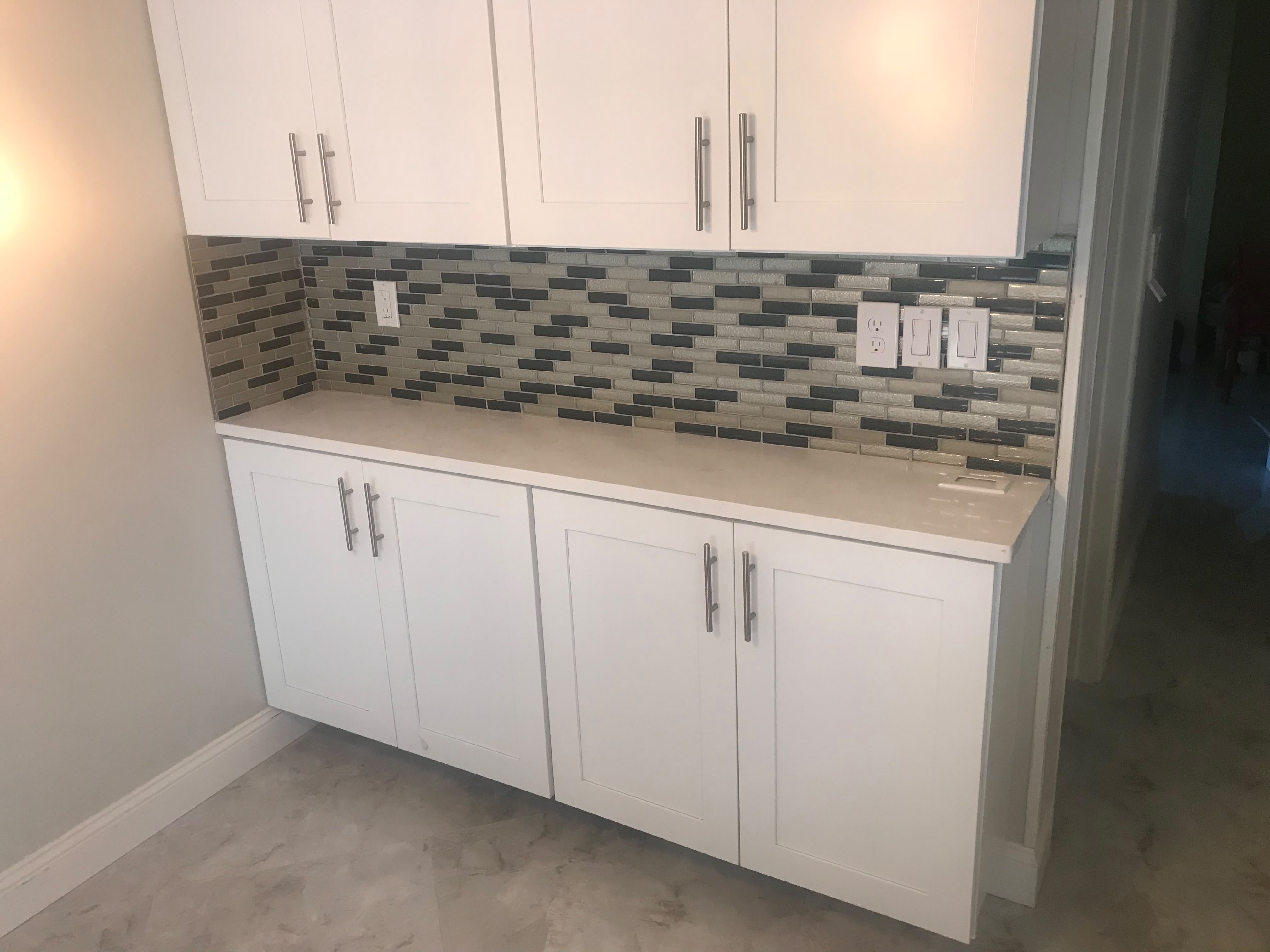 White cabinetry with glass mosaic backsplash