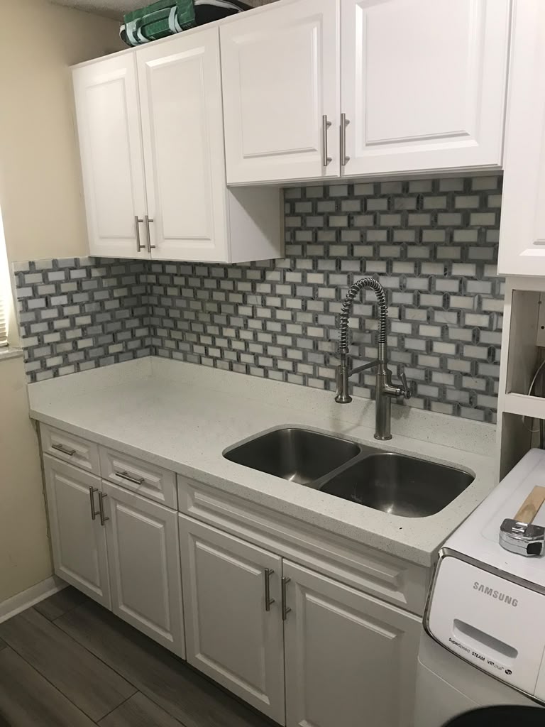 White kitchen cabinets and tiled backsplash